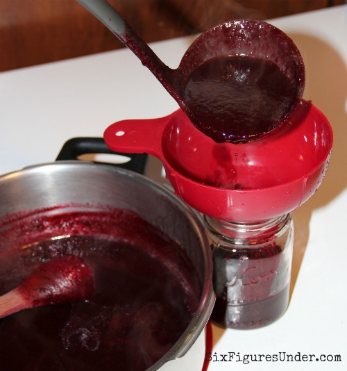 Ladle your hot blackblerry syrup into hot canning jars. This homemade blackberry syrup is seriously the BEST!